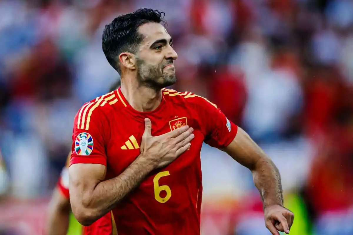 Jugador de fútbol con la camiseta roja de la selección española celebrando en el campo.