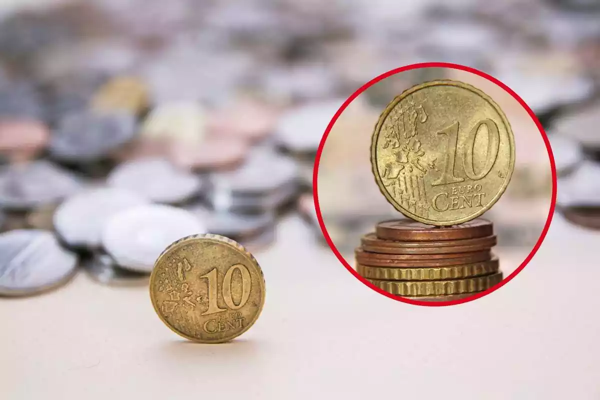 Montaje con una moneda de 10 céntimos sobre un montón de monedas y otra en primer plano