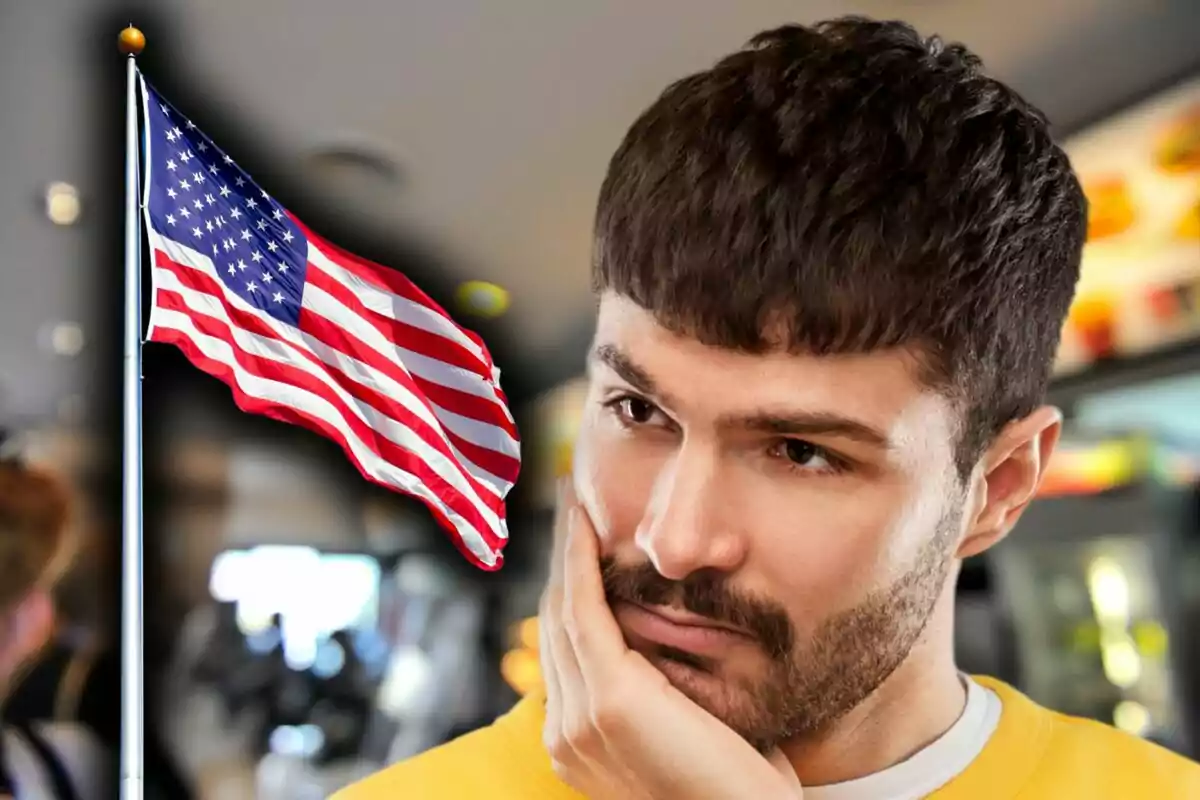 Un hombre pensativo con una bandera de Estados Unidos ondeando al fondo.