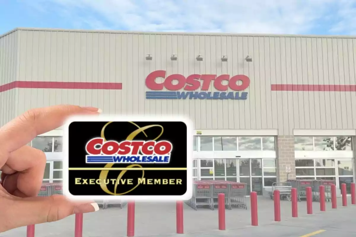 Persona sosteniendo una tarjeta de membresía ejecutiva de Costco frente a la entrada de una tienda Costco Wholesale.