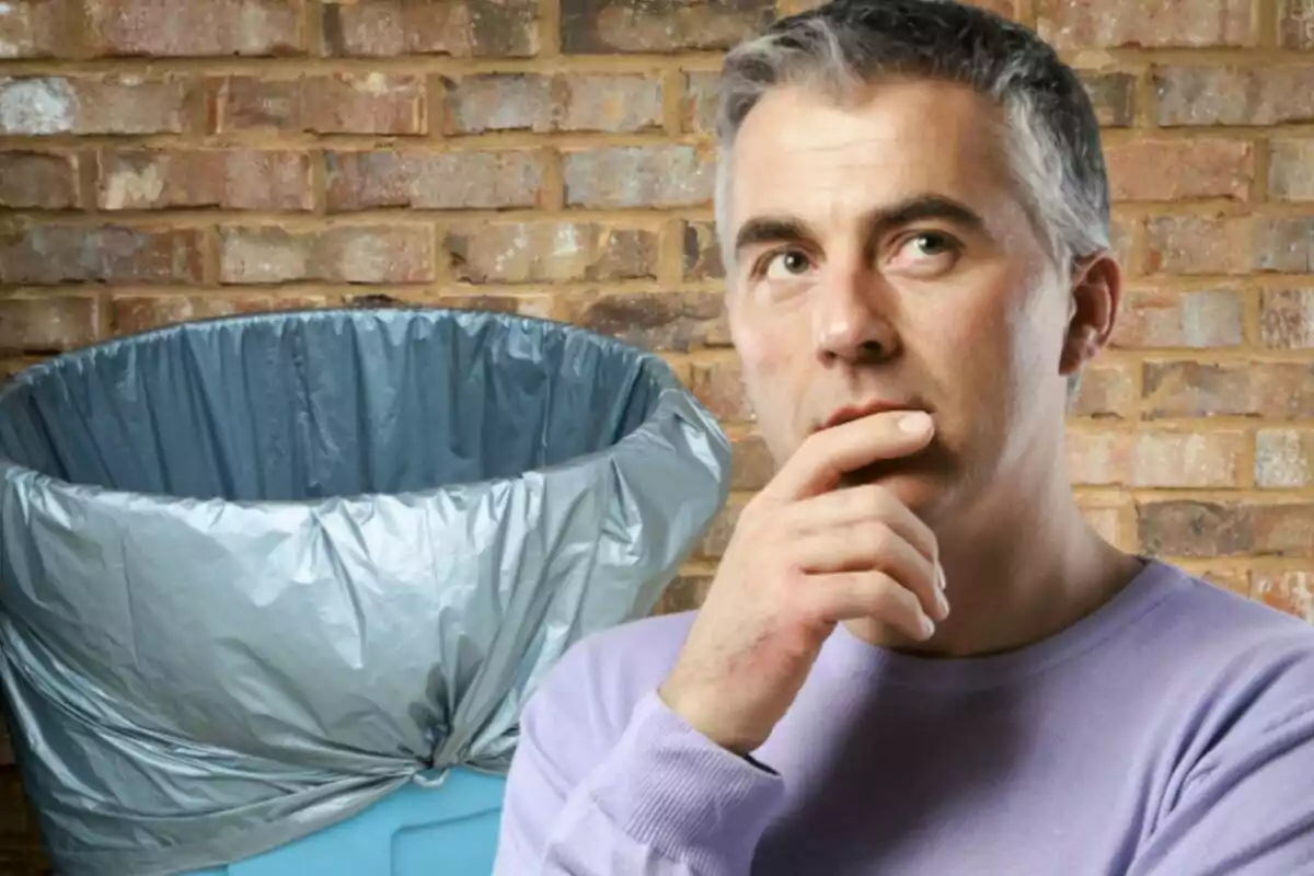 Pensive man in front of a trash can with a brick background. Pensive man in front of a trash can with a brick background.