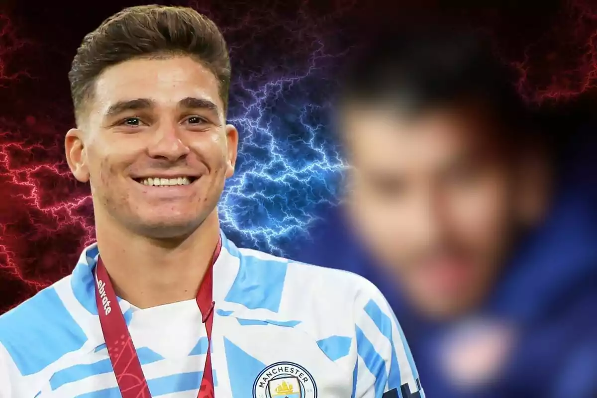 Un jugador de fútbol sonríe mientras lleva una medalla y una camiseta del Manchester City, con un fondo de rayos rojos y azules.