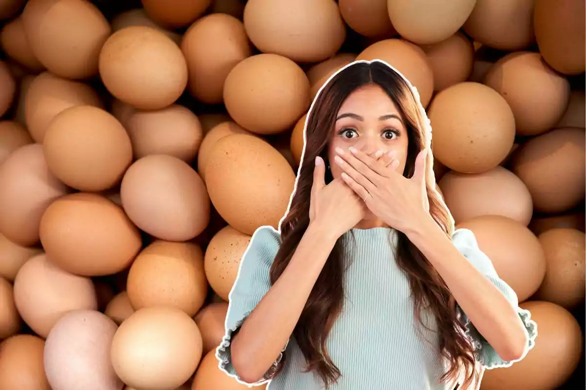 A woman with a surprised expression covers her mouth with her hands in front of a background of brown eggs. A woman with a surprised expression covers her mouth with her hands in front of a background of brown eggs.