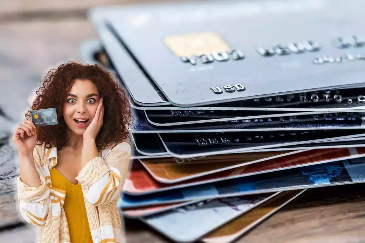 Una mujer enseña una tarjeta de crédito, con un montón de tarjetas al fondo