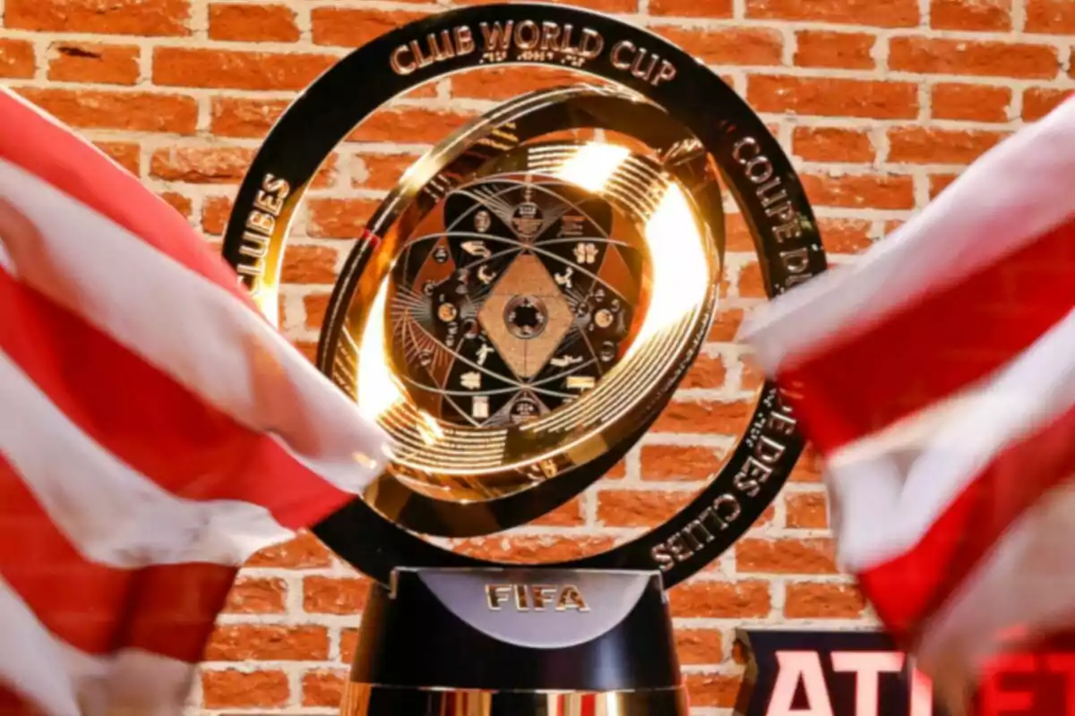 Trofeo del Mundial de Clubes de la FIFA con fondo de ladrillos y banderas rojas y blancas.