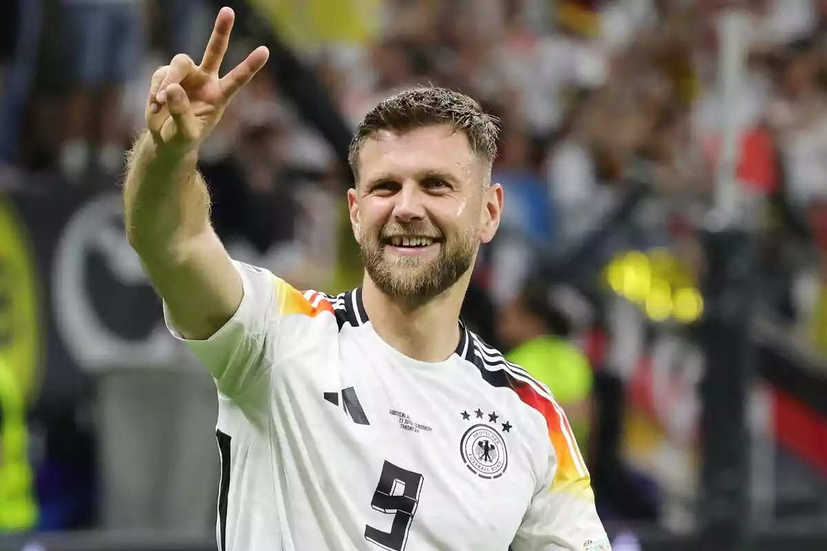 Jugador de fútbol alemán celebrando con la camiseta de la selección de Alemania.