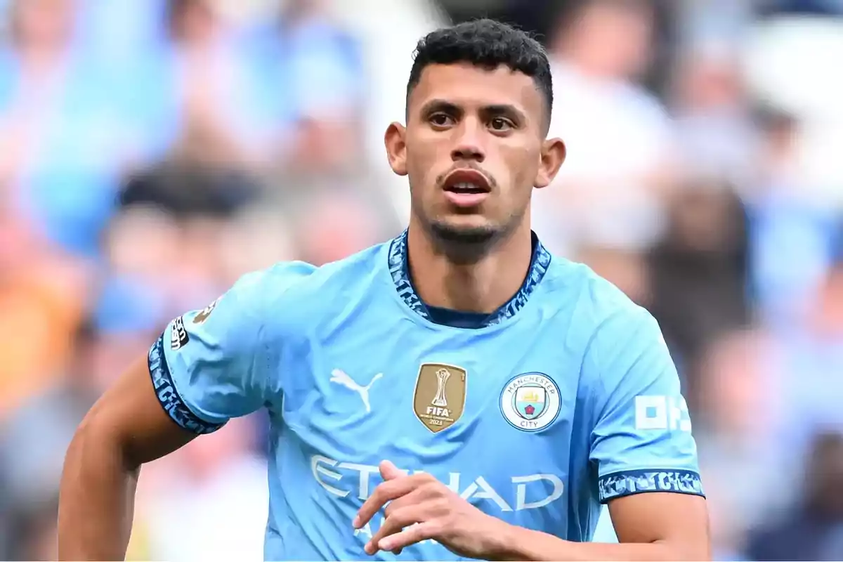 A football player wearing a Manchester City shirt on the pitch. A football player wearing a Manchester City shirt on the pitch.