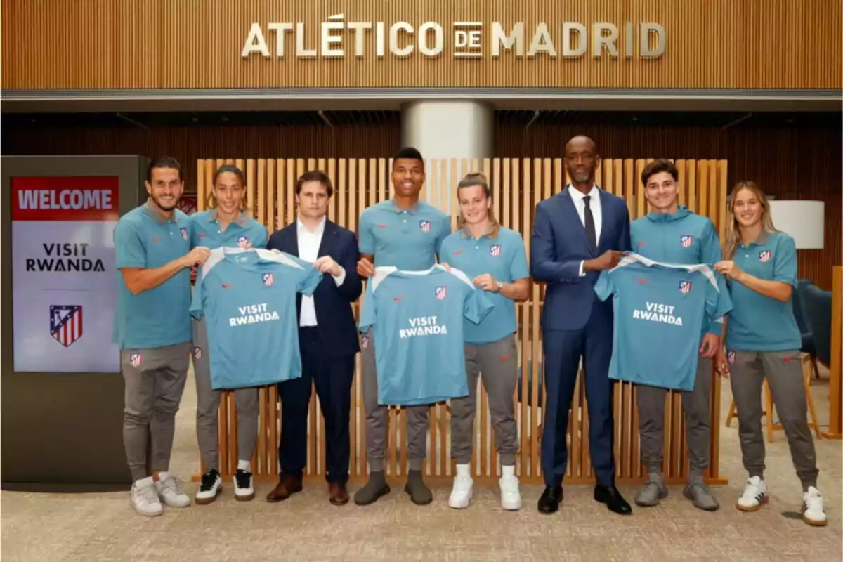 Un grupo de personas posa con camisetas del Atlético de Madrid que tienen el logo de Un grupo de personas posa con camisetas del Atlético de Madrid que tienen el logo de