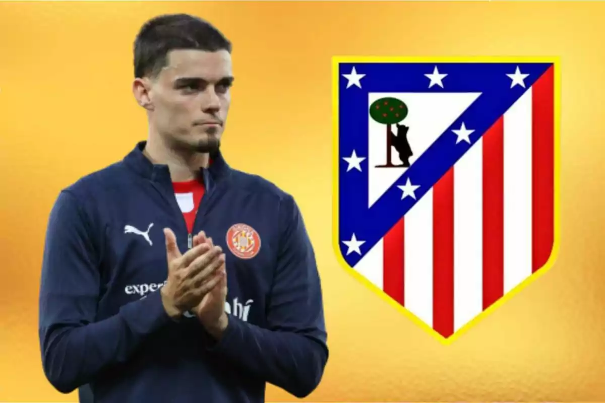 Un jugador de fútbol aplaudiendo con el escudo del Atlético de Madrid al fondo sobre un fondo amarillo.