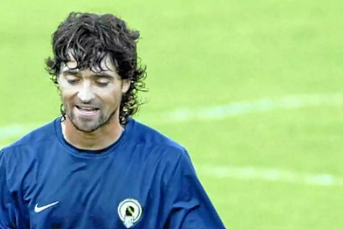 Un hombre con camiseta azul en un campo de fútbol. Un hombre con camiseta azul en un campo de fútbol.