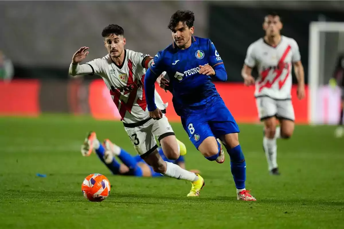 Jugadores de fútbol compiten por el balón en un partido. Jugadores de fútbol compiten por el balón en un partido.