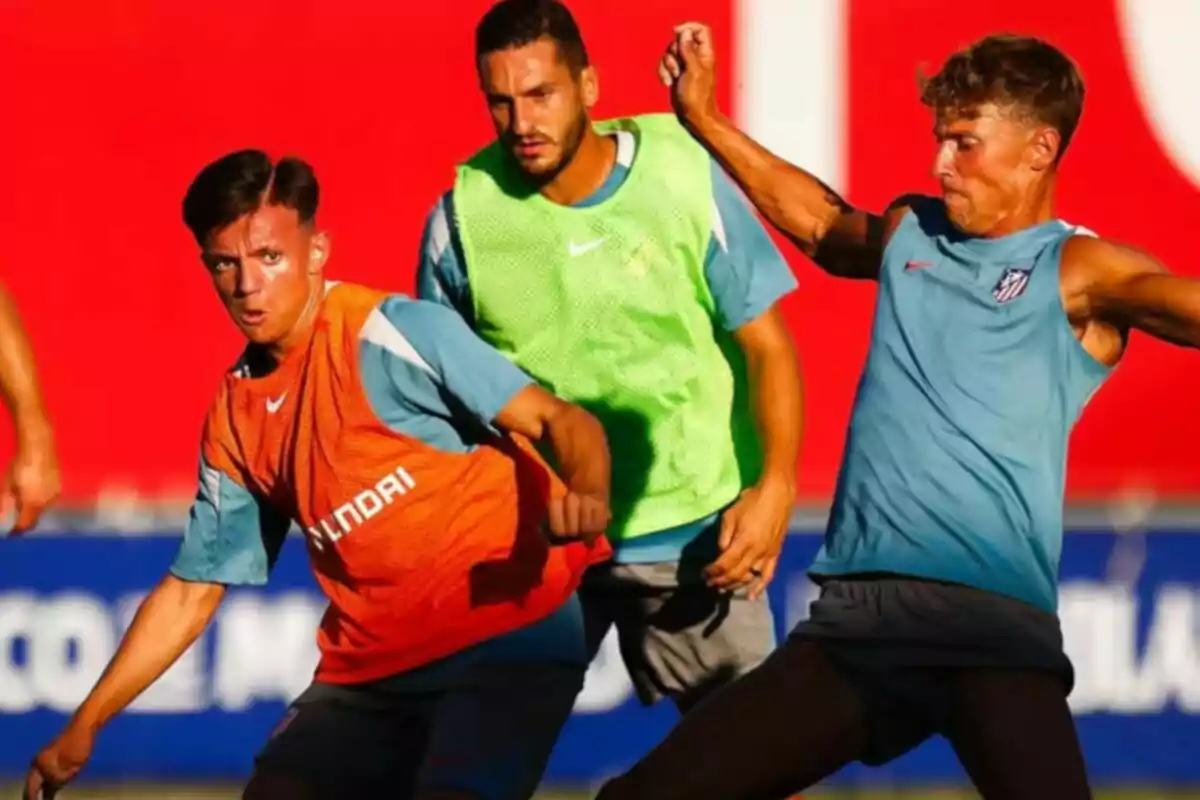 Jugadores de fútbol entrenando con petos de diferentes colores en un campo. Jugadores de fútbol entrenando con petos de diferentes colores en un campo.
