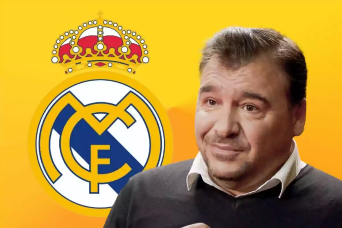 Hombre con camisa blanca y suéter oscuro frente al logo del Real Madrid sobre un fondo amarillo.