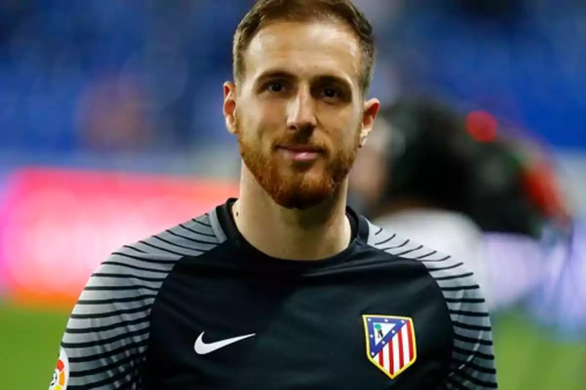 Un jugador de fútbol con barba y camiseta del Atlético de Madrid.