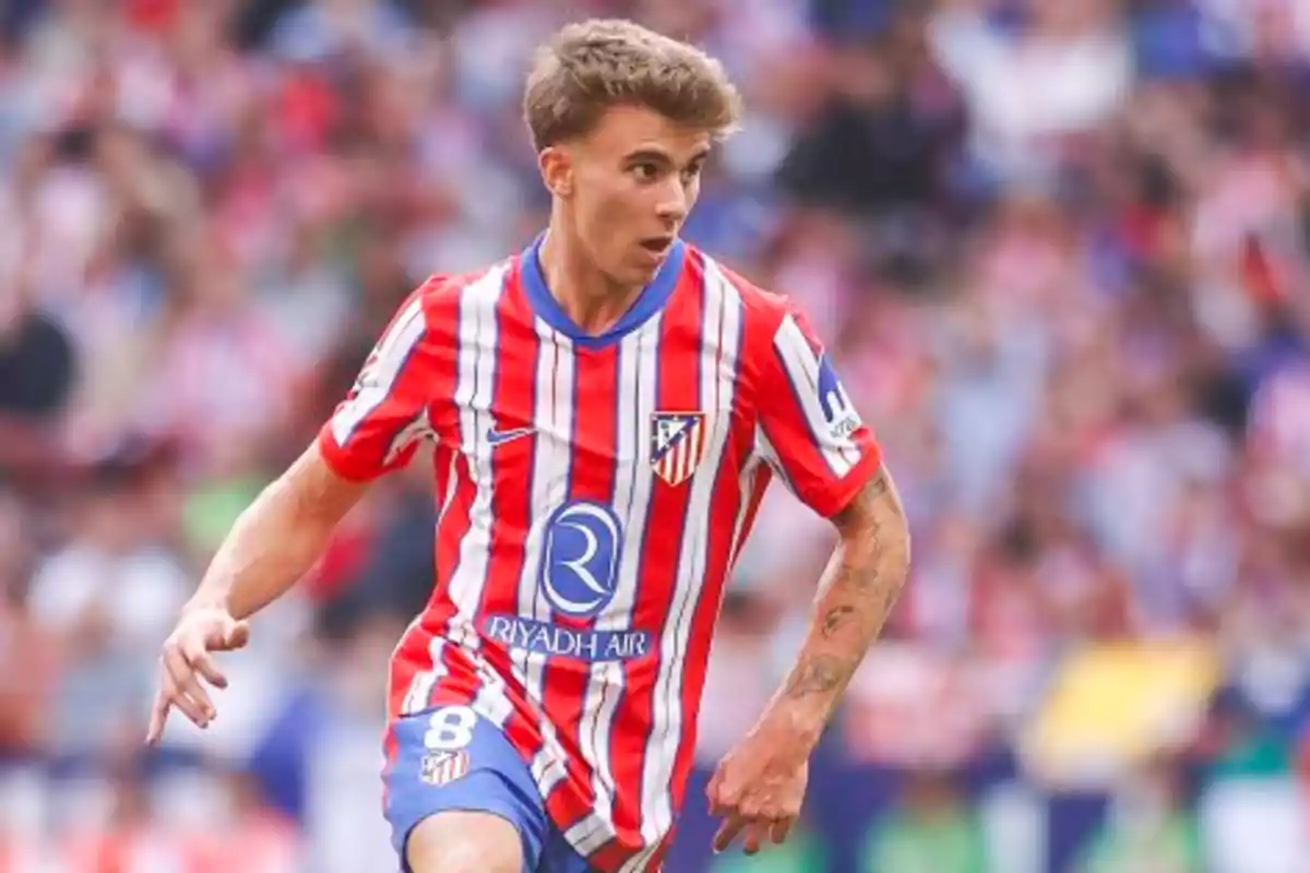 Jugador de fútbol con uniforme rojo y blanco en acción durante un partido.