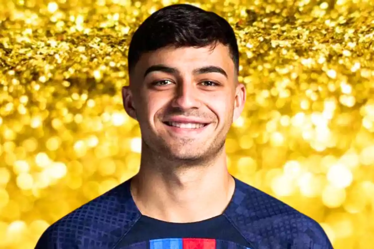 Un joven sonriente con cabello corto y oscuro, vestido con una camiseta azul con detalles en rojo y azul, posando frente a un fondo dorado brillante.