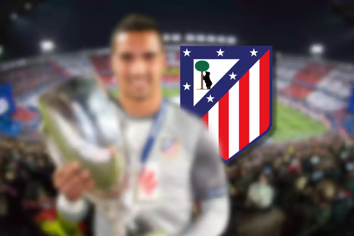 Un jugador de fútbol sosteniendo un trofeo con el escudo del Atlético de Madrid en el fondo.