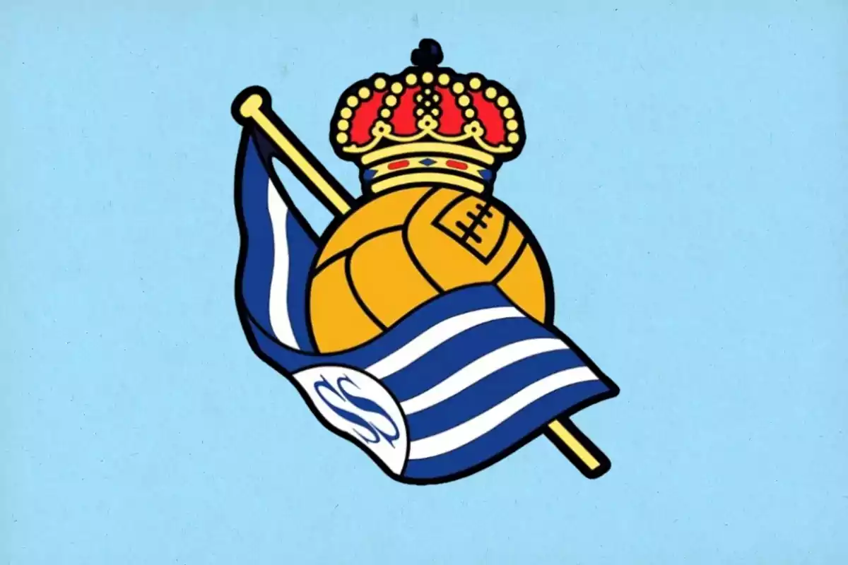 Escudo de un equipo de fútbol con una corona roja y dorada sobre un balón amarillo y una bandera azul y blanca ondeando.