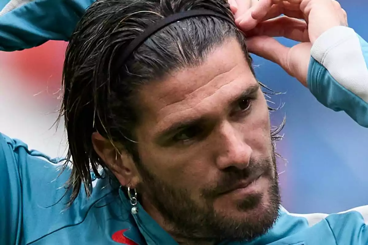 Hombre con cabello largo y barba ajustándose una cinta en la cabeza.