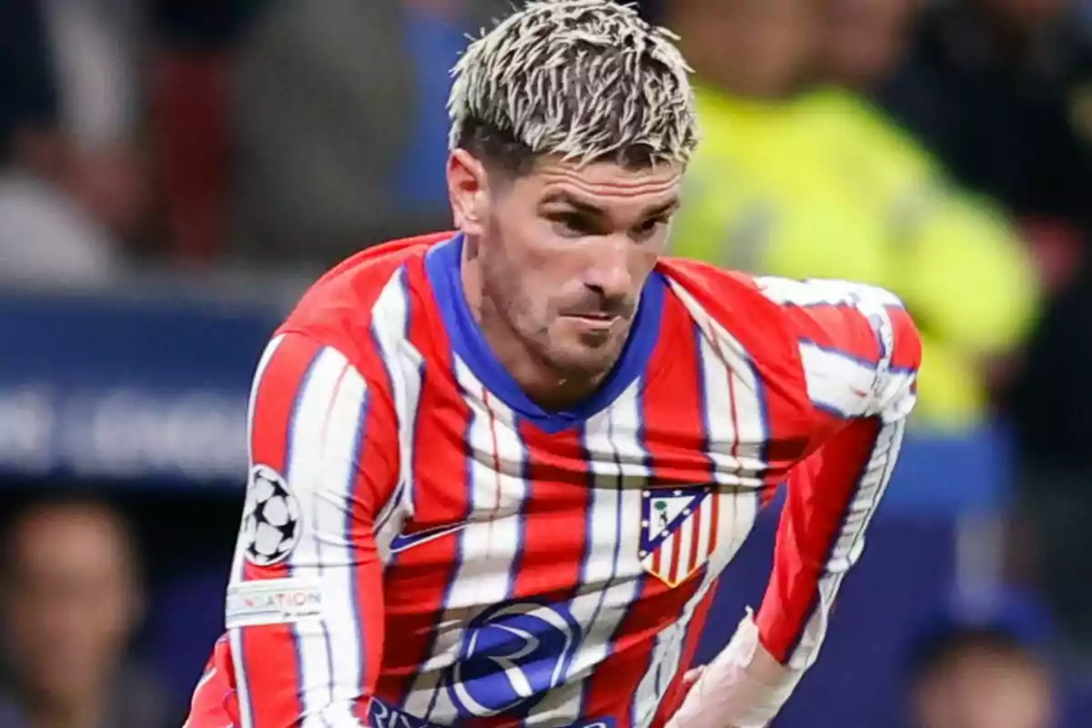 Jugador de fútbol con uniforme del Atlético de Madrid durante un partido.