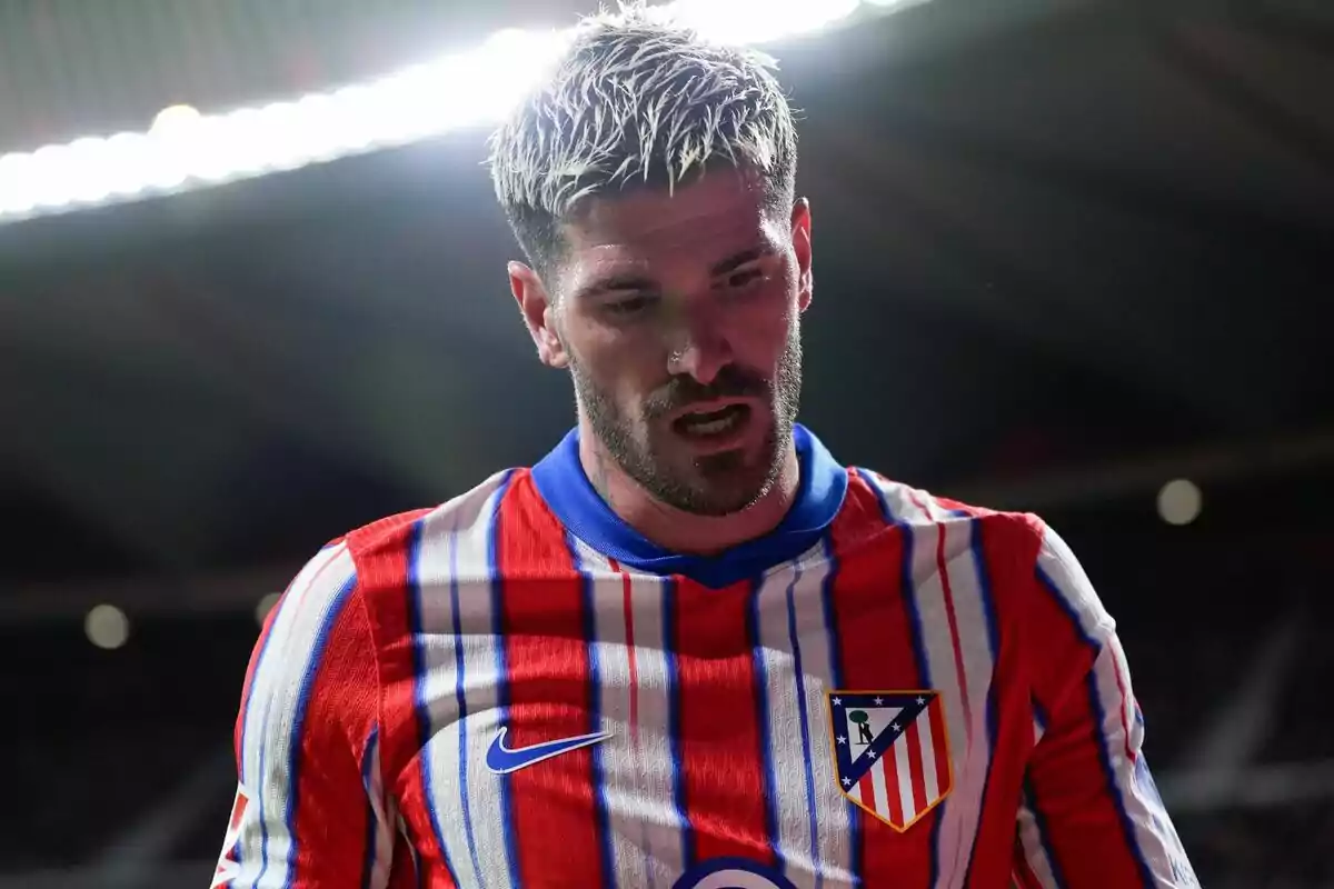 Jugador de fútbol con camiseta del Atlético de Madrid en un estadio.