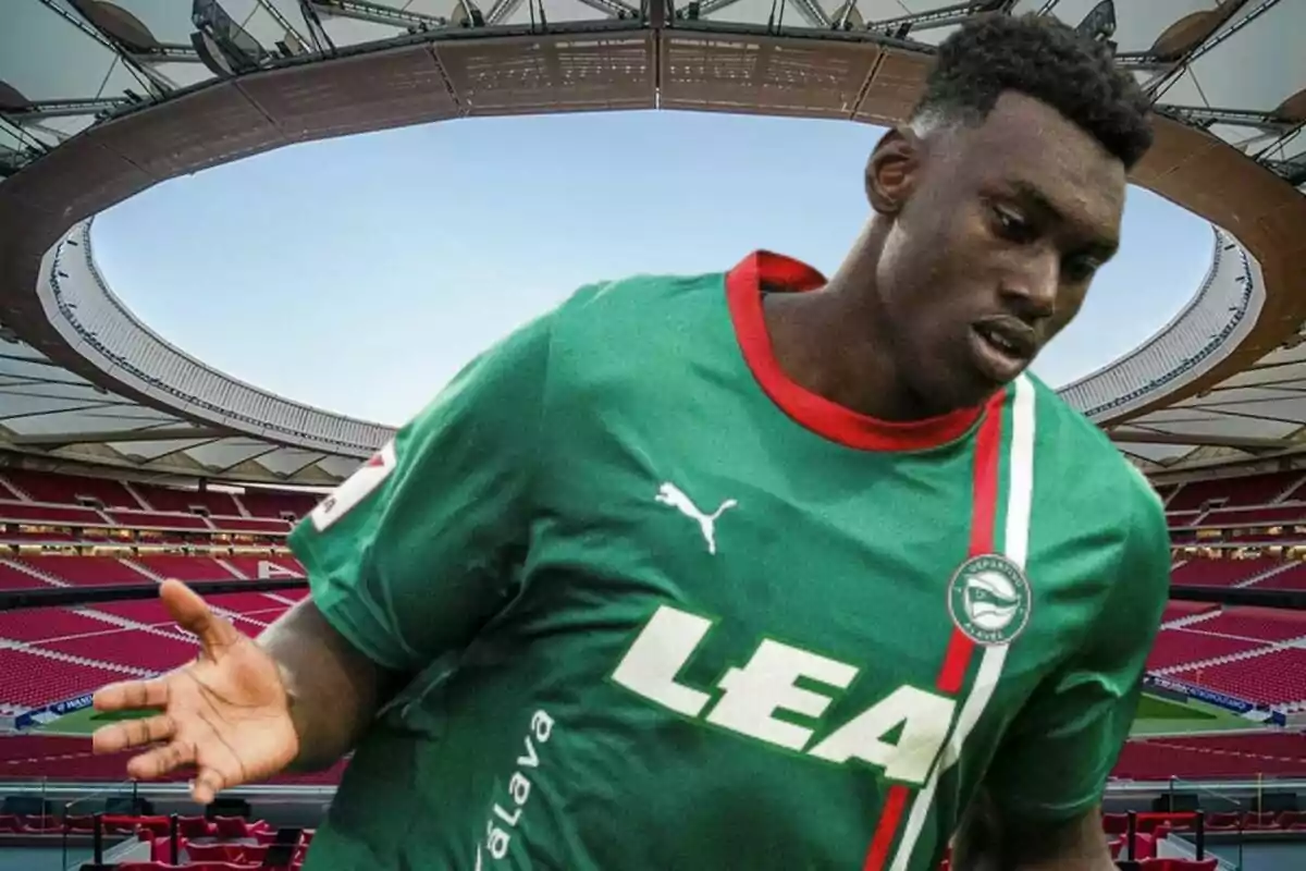 Un jugador de fútbol con camiseta verde y roja en un estadio.