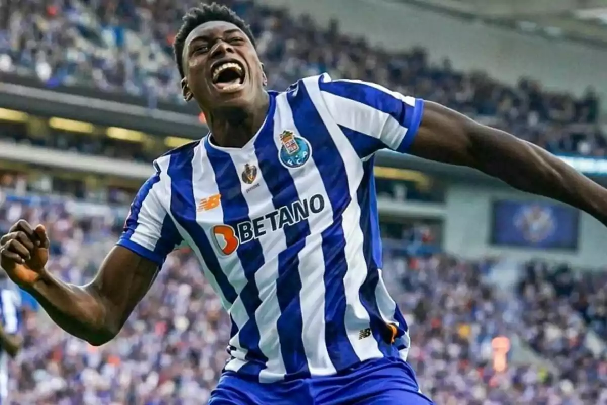 Jugador de fútbol celebrando un gol con la camiseta del FC Porto en un estadio lleno de espectadores.