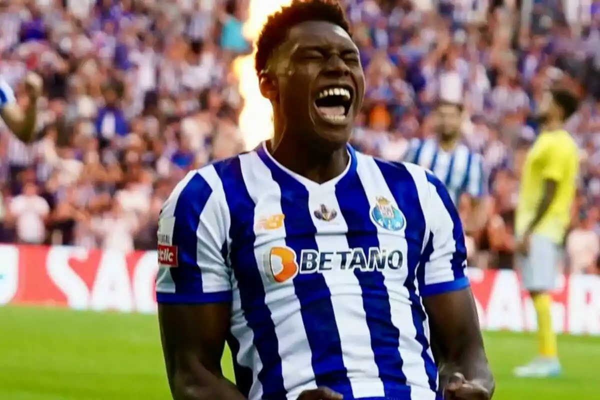 Jugador de fútbol celebrando un gol con la camiseta del FC Porto en un estadio lleno de aficionados.