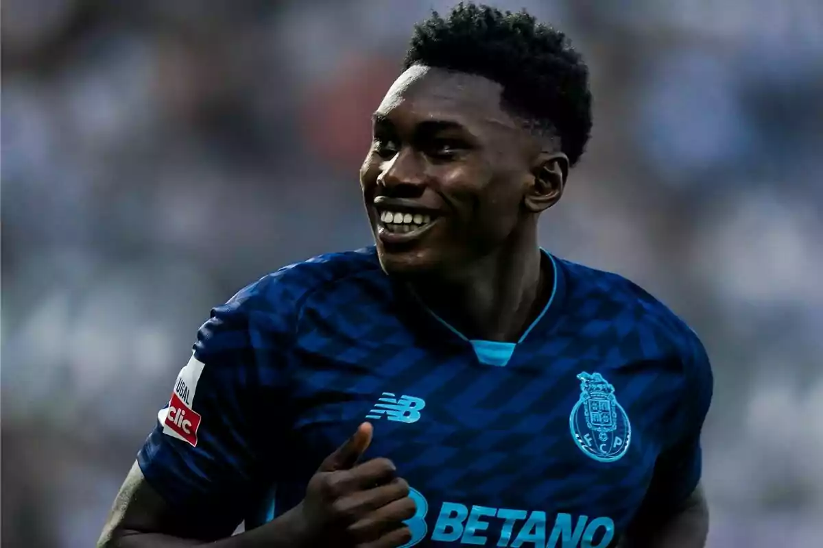 Jugador de fútbol sonriendo y vistiendo el uniforme del FC Porto durante un partido.