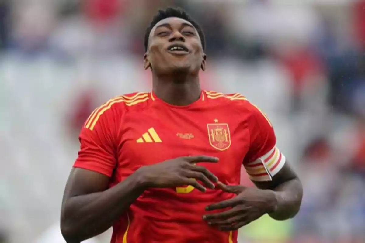 Un jugador de fútbol con la camiseta roja de la selección de España celebra en el campo.