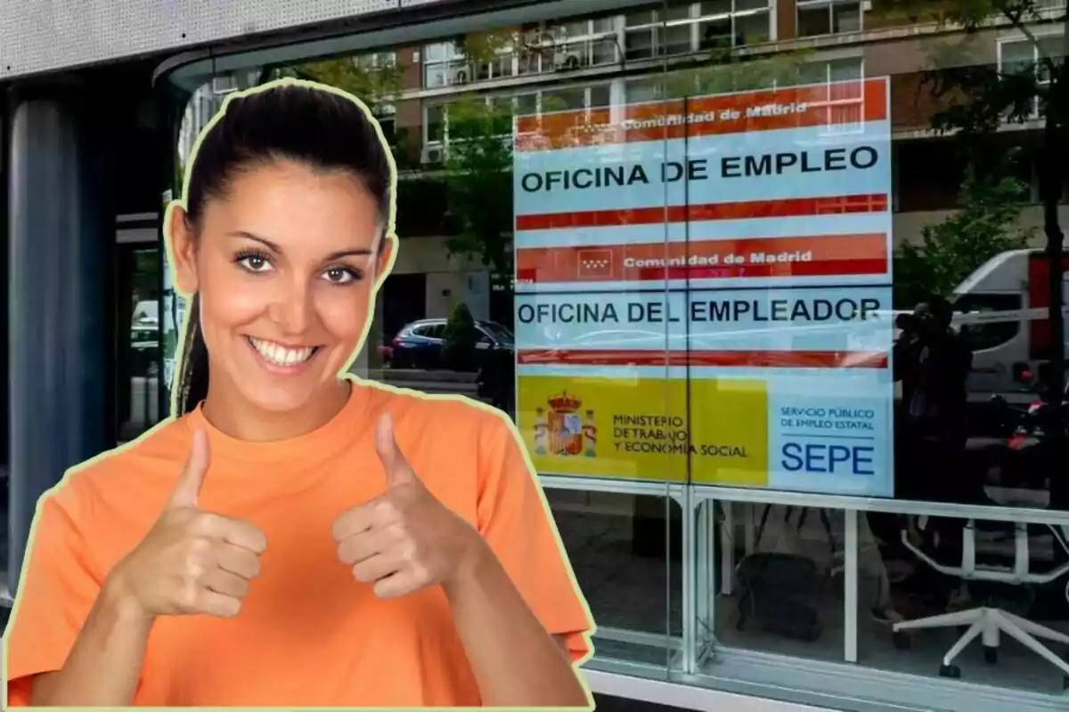 Una mujer sonriente con camiseta naranja levantando ambos pulgares frente a una oficina de empleo de la Comunidad de Madrid.