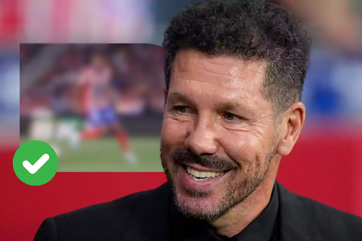 Un hombre sonriente con barba y cabello rizado, vestido con un traje negro, con una imagen borrosa de un jugador de fútbol en el fondo y un icono de verificación verde en la esquina inferior izquierda.