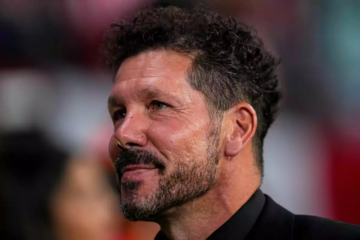 Hombre con barba y cabello rizado mirando hacia la derecha.