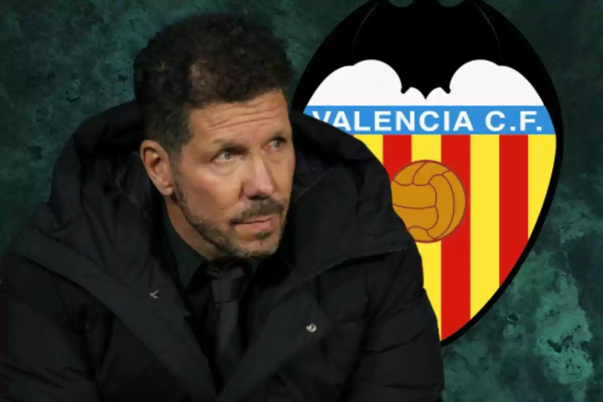 A man in a black jacket is in front of a Valencia C.F. crest.