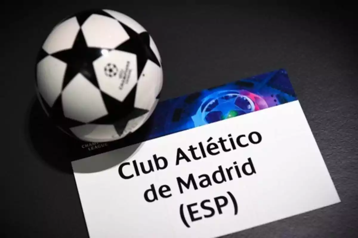 Pelota de la UEFA Champions League junto a una tarjeta con el nombre del Club Atlético de Madrid (ESP).