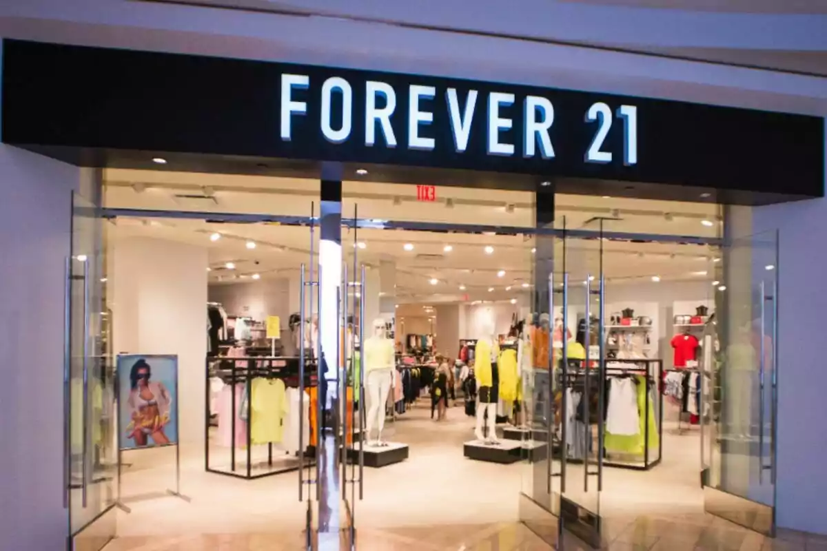 Tienda de ropa Forever 21 con entrada de puertas de vidrio y maniquíes exhibiendo prendas en el interior. Tienda de ropa Forever 21 con entrada de puertas de vidrio y maniquíes exhibiendo prendas en el interior.
