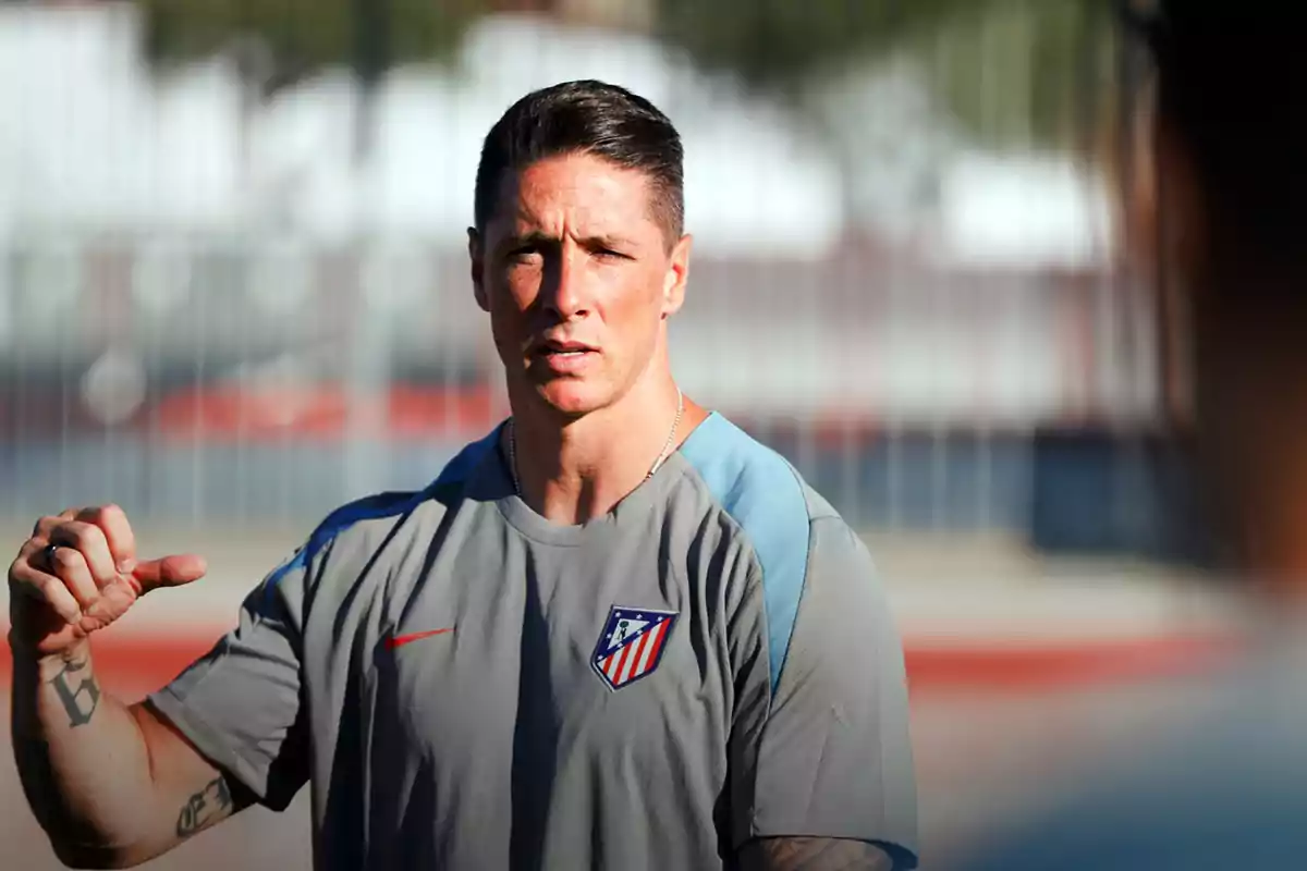 Hombre con camiseta del Atlético de Madrid gesticulando al aire libre.