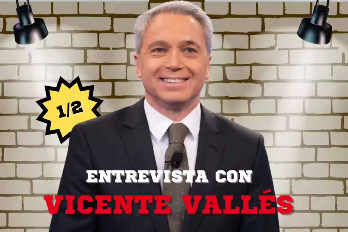 Un hombre con traje y corbata sonríe frente a un fondo de ladrillos con luces y un gráfico que dice "1/2" y "Entrevista con Vicente Vallés".